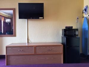 a room with a dresser with a television on a wall at Regency Inn in Winnemucca