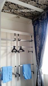 マイセンにあるFewo Meissenのベッドルーム(青と白のカーテン、ハンガー付)