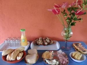 a table topped with plates of food and a vase of flowers at Sítio Canoas in Albuquerque