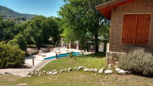 a house with a flock of sheep in the yard at Cabañas Los Gauchitos in La Falda