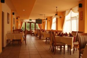 a dining room with tables and chairs and windows at Pension Andronic in Timişoara