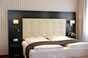 um quarto com uma cama grande e uma cabeceira preta em Hotel Herbst Berlin em Berlim