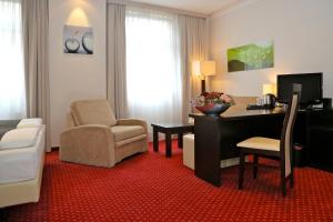 ベルリンにあるホテル ハーベスト ベルリンのデスクと椅子が備わるホテルルームです。