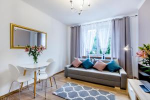 a living room with a couch and a table at ClickTheFlat Avenue Place Apart Rooms in Warsaw