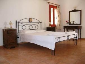 ein großes Bett in einem Zimmer mit einem Spiegel in der Unterkunft Hotel Heleni Apartments in Antikes Epidauros