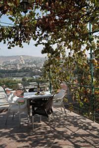 een tafel en stoelen op een balkon met uitzicht bij Cherdachok in Tbilisi City