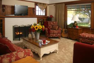 a living room with a fireplace and a table with flowers at Cottage on Armstrong in Lodi