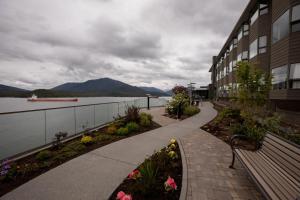 a walkway next to a building next to a lake at Crest Hotel in Prince Rupert