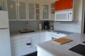 a kitchen with white cabinets and a counter top at Meadowbrook Guest Suite in Brentwood Bay