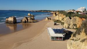 una playa con un edificio con paneles solares en Villa Figueira, en Portimão