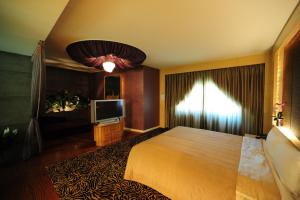 Habitación de hotel con cama y TV de pantalla plana. en Golden Motel en Hsinchu City
