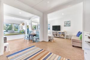 a living room with a couch and a table at The Little Blue Bach in Oneroa Village by Waiheke Unlimited in Oneroa
