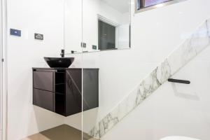 a bathroom with a sink and a glass wall at Abbey Motor Inn in Grafton +32 photos