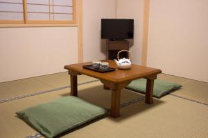 Habitación con mesa y hervidor de agua. en Kamoya Ryokan, en Kioto