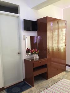 a bathroom with a wooden cabinet and a mirror at Brielles Travellers Inn in Tagbilaran City