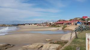 a beach with a group of houses and boats on it at Casa Nuestro Sueño in Punta Del Diablo