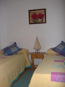 a bedroom with two beds and a table with a picture on the wall at La Villa Priego de Cordoba in Priego de Córdoba