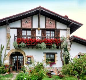 une maison avec des boîtes de fleurs sur son côté dans l'établissement Casa Rural Iketxe, à Fontarrabie