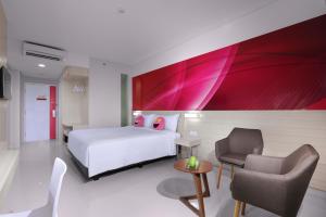 Habitación de hotel con cama y silla en favehotel Bandara Tangerang, en Tangerang