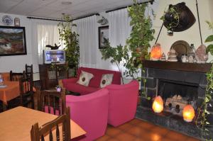 a living room with pink furniture and a fireplace at Hotel Castillo d'Acher in Siresa