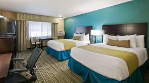 a hotel room with two beds and a desk at Best Western Long Beach Inn in Long Beach