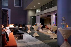 a lobby with tables and chairs in a building at Hyatt House San Jose-Silicon Valley in San Jose