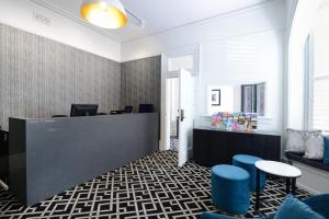 a lobby with a reception desk and blue stools at High Cross Randwick by Sydney Lodges in Sydney