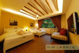 a bedroom with two beds and a flat screen tv at Hsitou Man Tuo Xiang Homestay in Lugu Lake