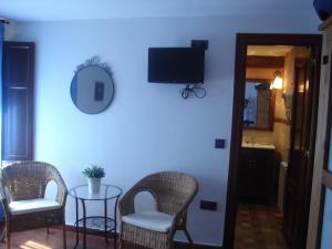 Una televisión o centro de entretenimiento en Hotel Mesón del Gallo