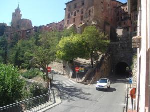 a white car driving down a street with a tunnel at Hotel Mesón del Gallo in Albarracín