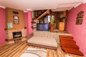 a living room with a fireplace and a tv at Mineral apartman Smaragd in Nyíregyháza