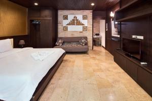 een slaapkamer met een bed en een bank in een kamer bij V Condominium Samui in Bophut 
