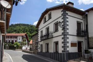 un edificio blanco al lado de una calle en Aiestaenea Apartamentos Rurales en Isaba