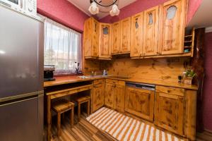 a kitchen with wooden cabinets and a refrigerator at Mineral apartman Smaragd in Nyíregyháza