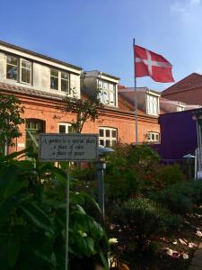 un cartello di fronte a un edificio con una bandiera di Oasen a Viborg