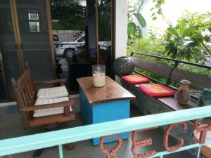 un porche con banco, mesa y sillas en Rec Art (House of recycle+Art) en Ko Samed