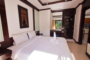 een groot wit bed in een kamer met een raam bij V Condominium Samui in Bophut 