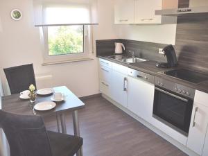 a small kitchen with a table and a sink at Ferienhaus Jäger in Friedrichshafen