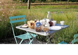 a picnic table with a basket of bread and a bottle at Coup 2 Foudres in Saint-Jean-de-Blaignac