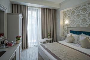 ブカレストにあるOld Town Boutique Hotelの大きなベッドとバスルームが備わるホテルルームです。
