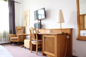 a hotel room with a desk and a tv at Hotel Braník in Prague