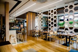 a restaurant with wooden floors and tables and chairs at Bulwary Biznes in Mielec