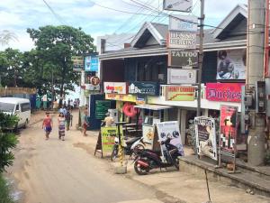 a group of people walking down a street next to a building at InnBox Bed & Bath in Panglao