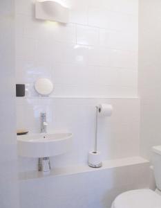 uma casa de banho branca com um lavatório e um WC em The Art Room Apartment em Cardigan