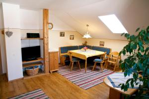 comedor y sala de estar con mesa y sillas en Stroblhof en Böbing