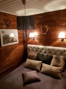 een bed in een kamer met houten wanden en 2 lampen bij Levinlento in Levi