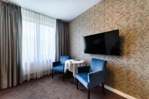 Televízia a/alebo spoločenská miestnosť v ubytovaní Hotel Nowy Dwór