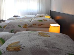a bed with a blanket and pillows on top of it at Studios near Basel Airport in Saint-Louis