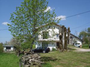 ein Auto, das vor einem Haus mit einem Baum parkt in der Unterkunft gite Loca in Provenchère