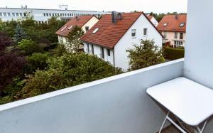 a white bench on a balcony with houses at Lovely studio in Augsburg in Augsburg